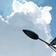 A solar lamp harnessing clean energy under a bright blue sky with fluffy clouds.